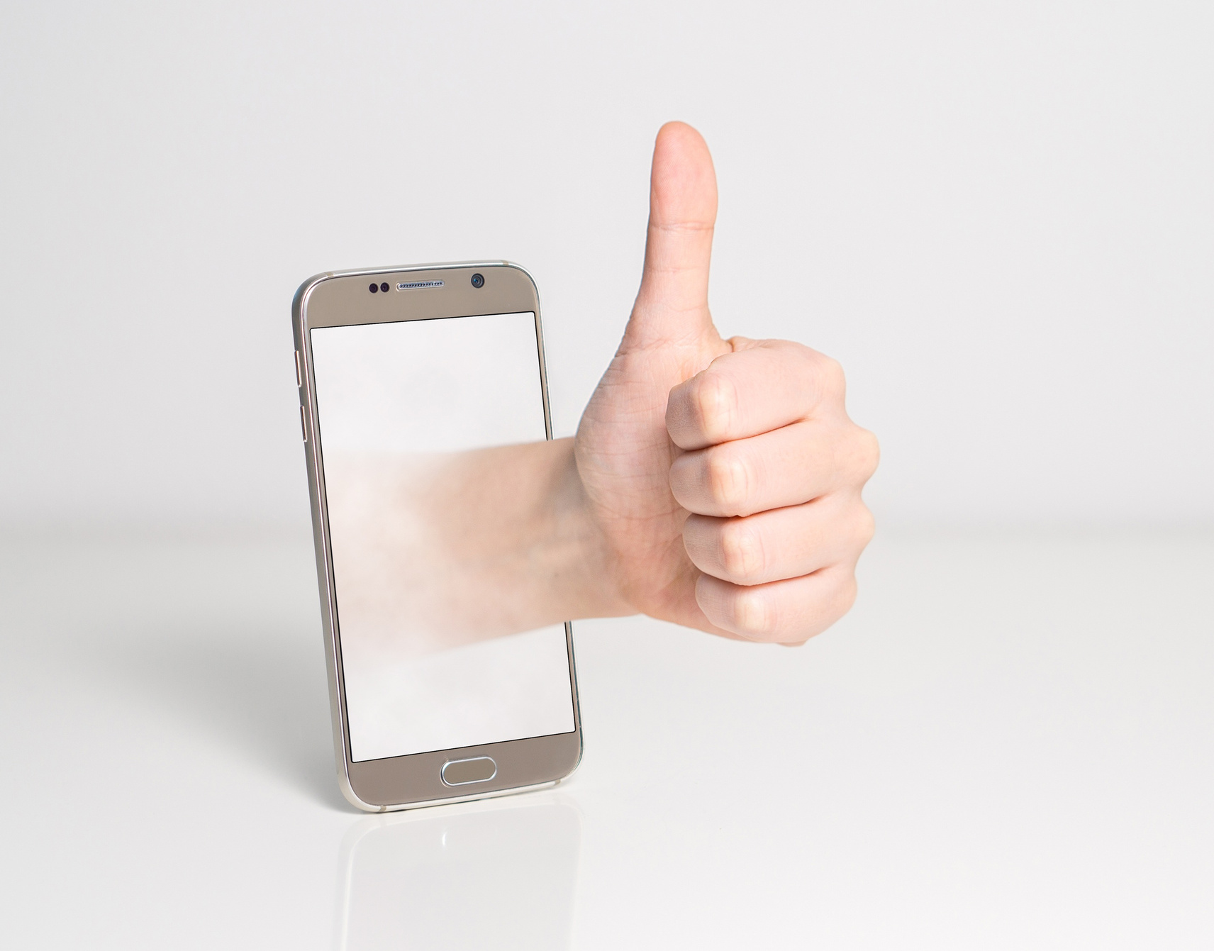 Hand Coming out from a Smarphone Showing Thumbs up